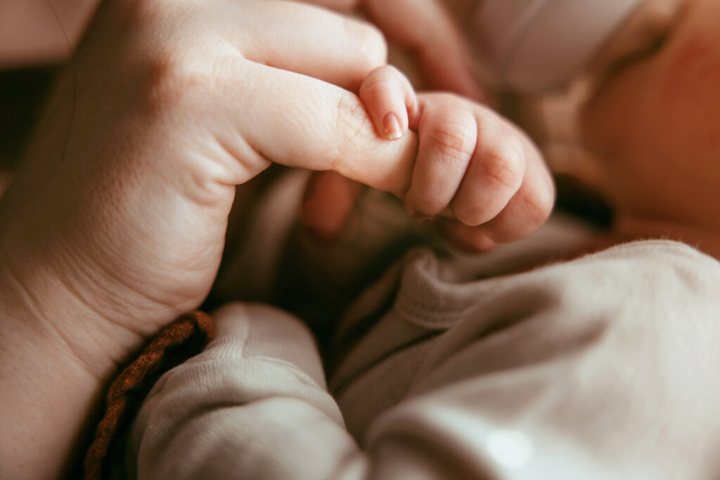 newborn holding mama's finger