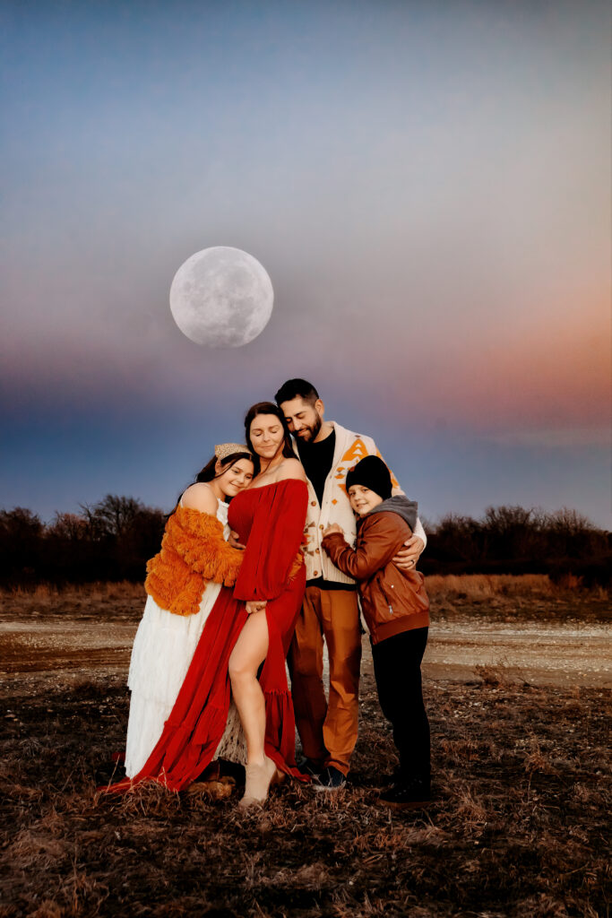 family snuggling by the light of the moon
