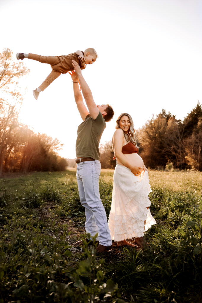 dad playing with big brother during maternity photos with siblings