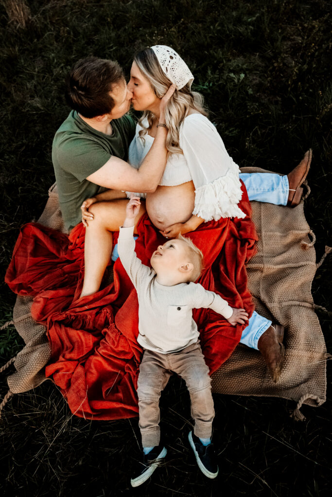 brother playing with dad and mom during maternity photos with siblings