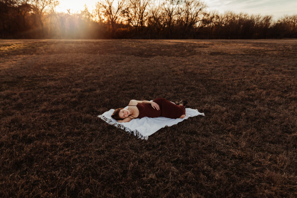 pregnancy momma laying on a blanket at sunset