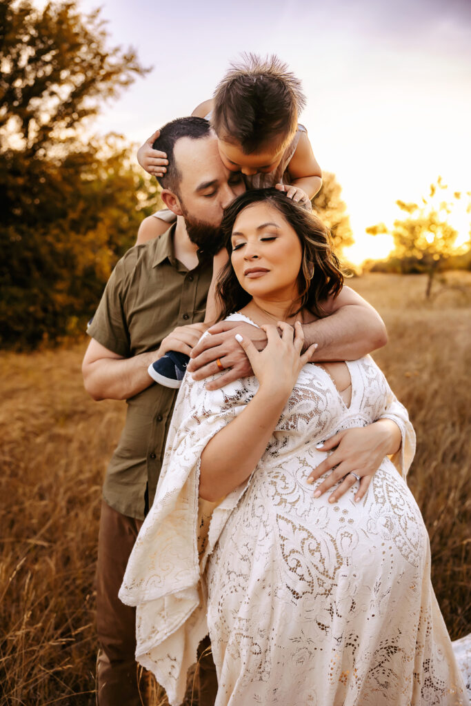 family loving on each other during maternity photos with siblings