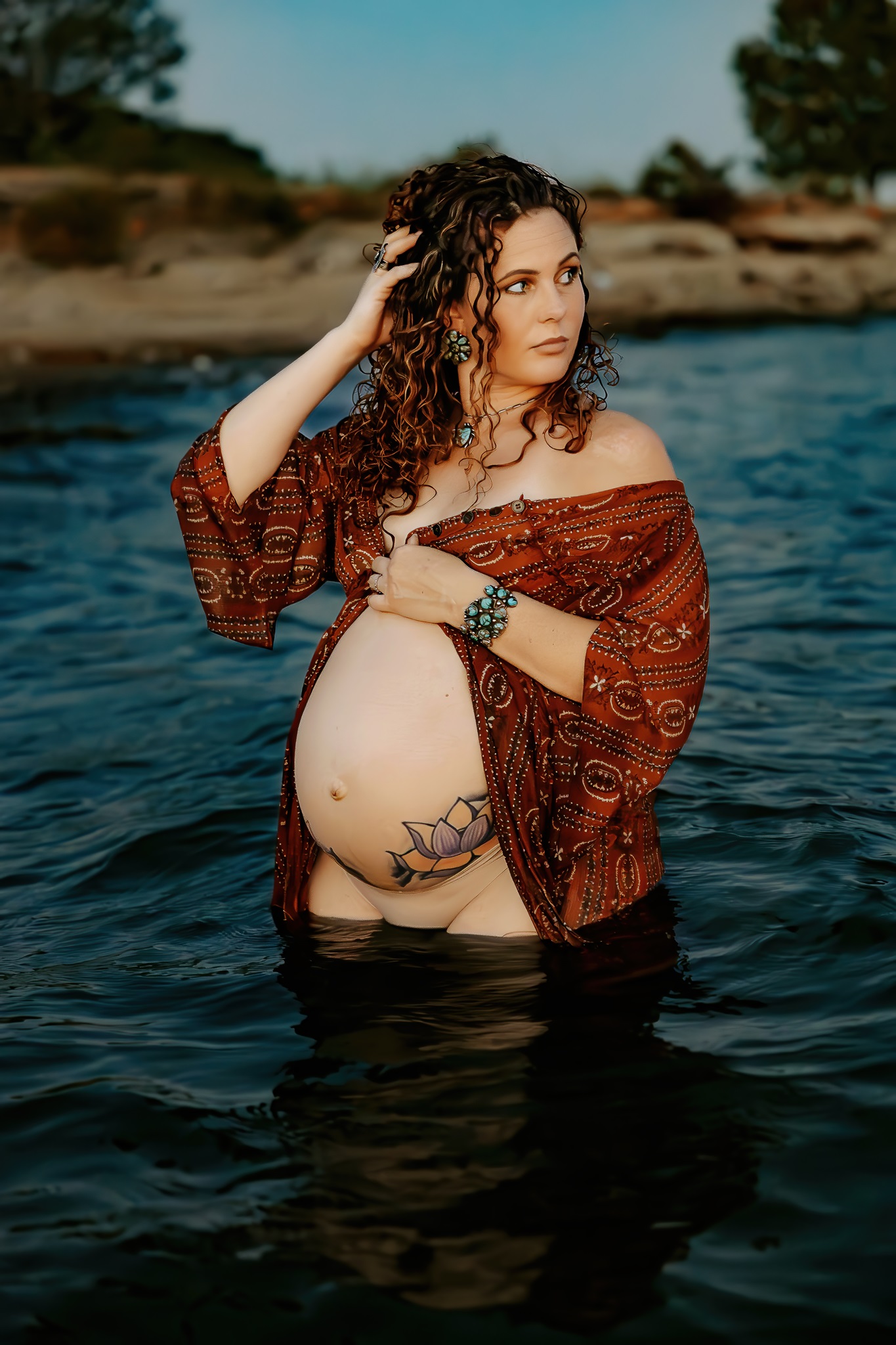woman stands in lake during maternity photoshoot