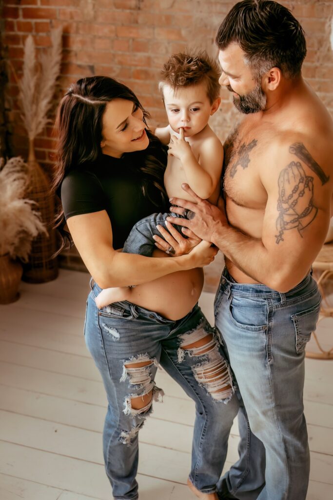 Mom and Dad loving on their oldest boy during a maternity photoshoot.