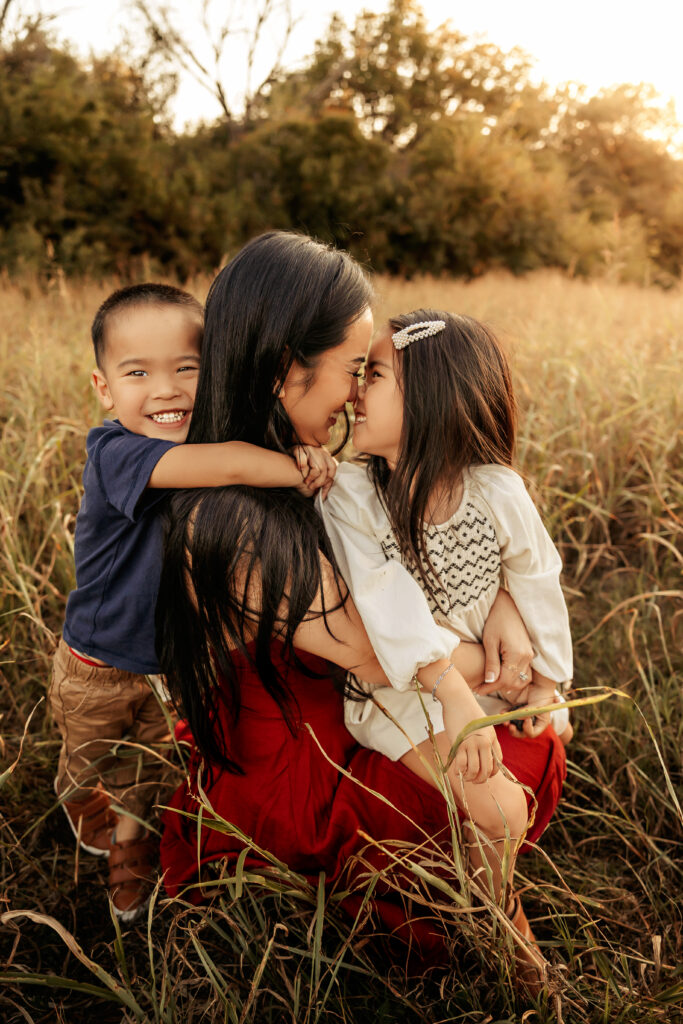 Mom holding toddler under soft sunset skies – Ft Worth Fall Mini Sessions