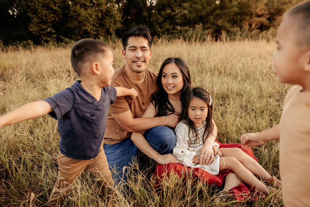 Family cuddling and playing together at sunset during Family Session in Fort Worth TX