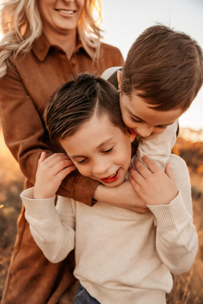 Younger brother piled on older brother's back during a playful moment captured by Fort Worth Family Photographer