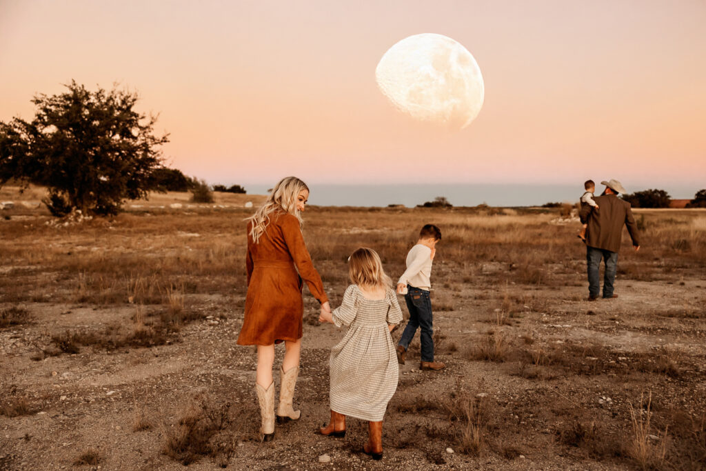 Siblings walking through moonlight at the end of a beautiful session, full of joy