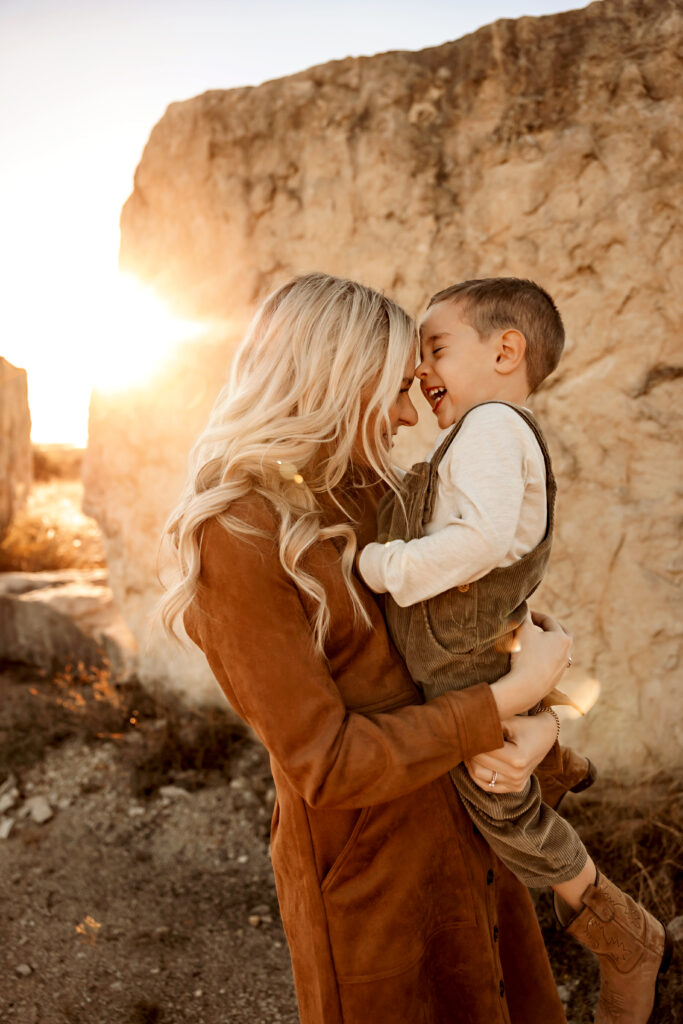mom and young son laughing with a golden glow