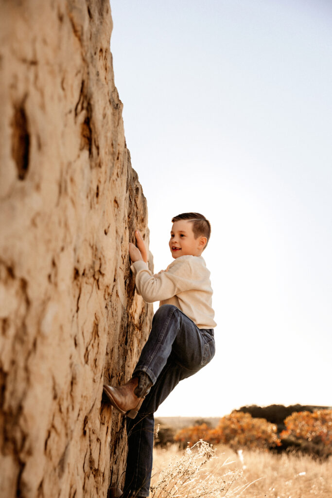 child rock climbing during a family sunset photo session