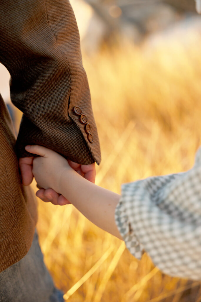 Close-up of child’s hands wrapped around dad's hand – emotive family photography Fort Worth TX