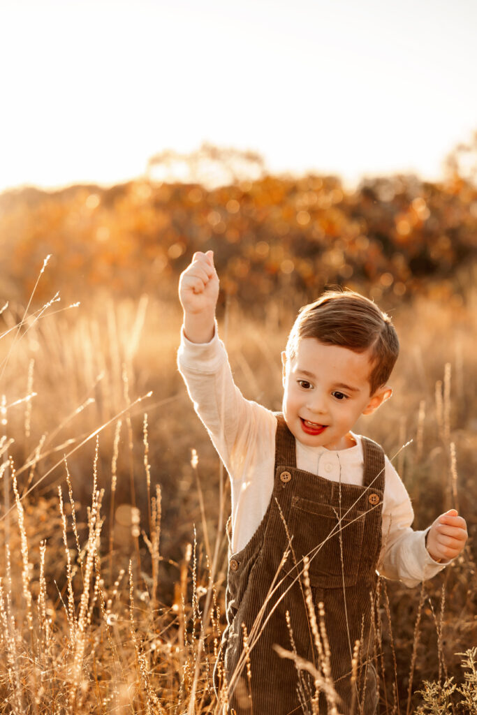 child playing in the long grass during sunset in fort worth texas