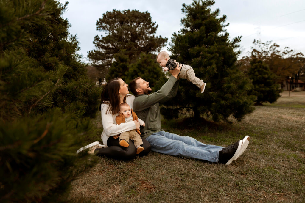 Family smiling together at Christmas tree farm during golden hour in Fort Worth