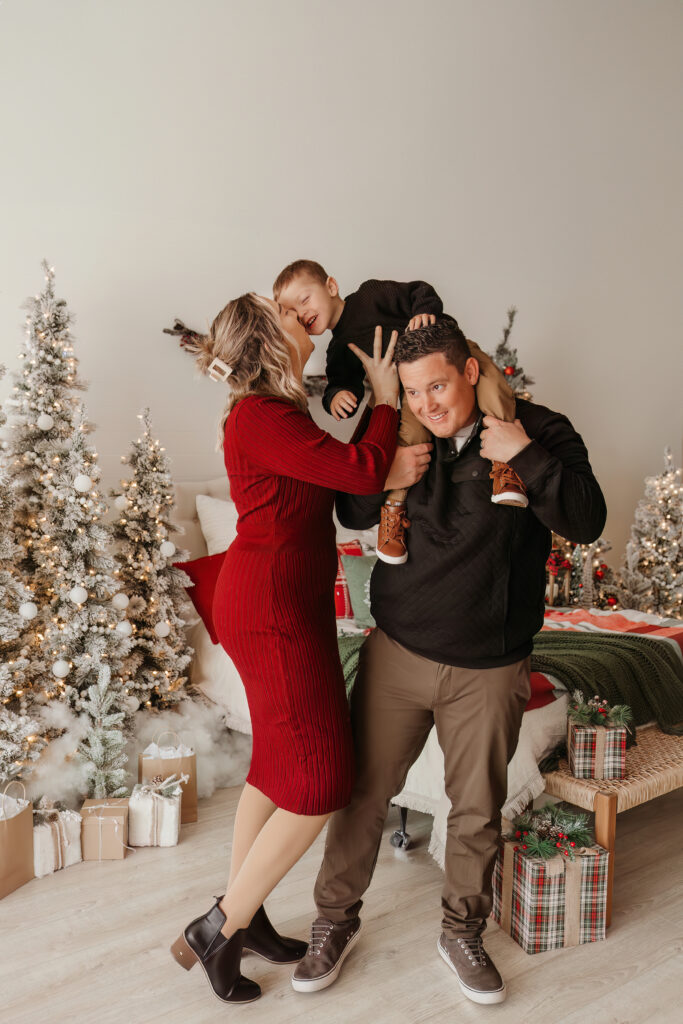 Dad lifting child above head during Christmas mini session in Texas