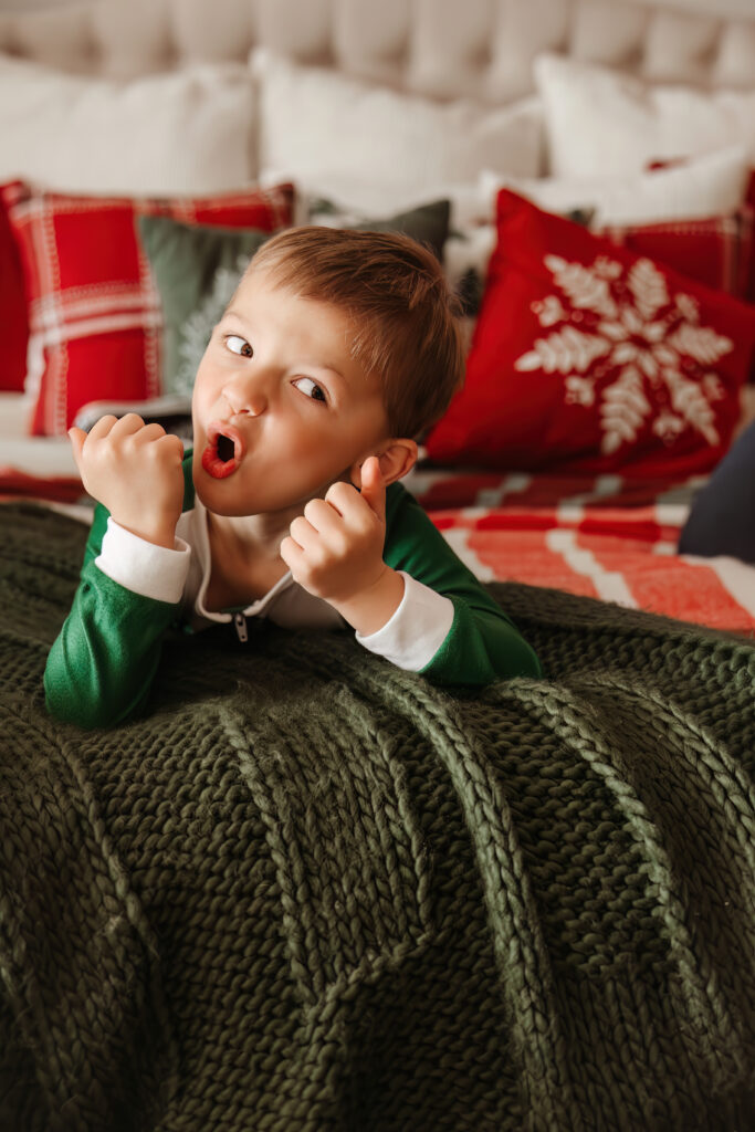 Child making silly faces on a bed during some Christmas Minis in Ft Worth