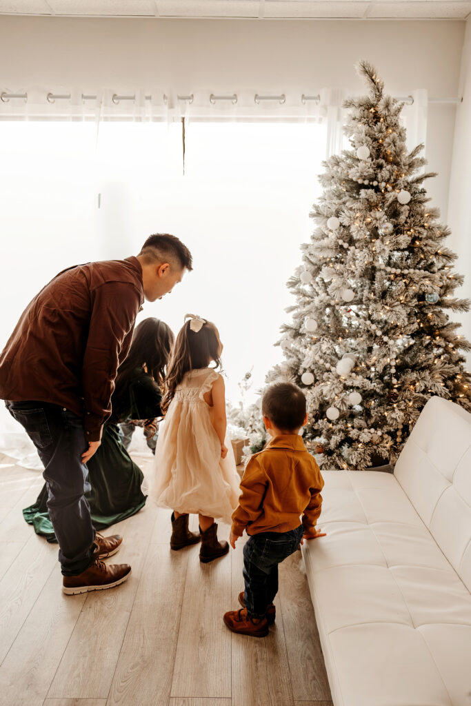 Kids laughing together during indoor Christmas family photo shoot
